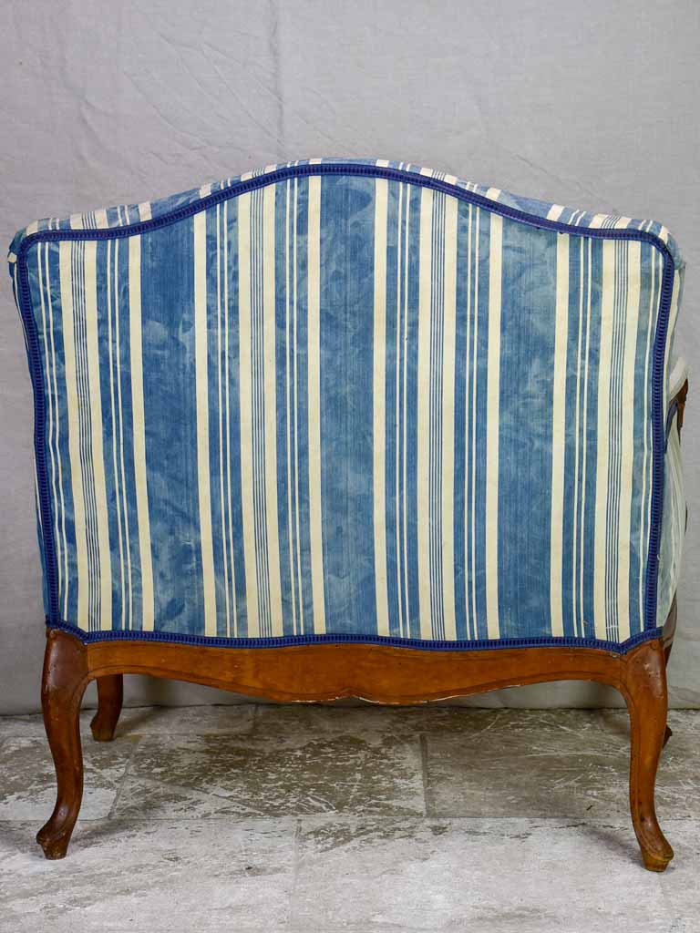 Large antique French Provincial armchair with striped blue and white upholstery walnut frame