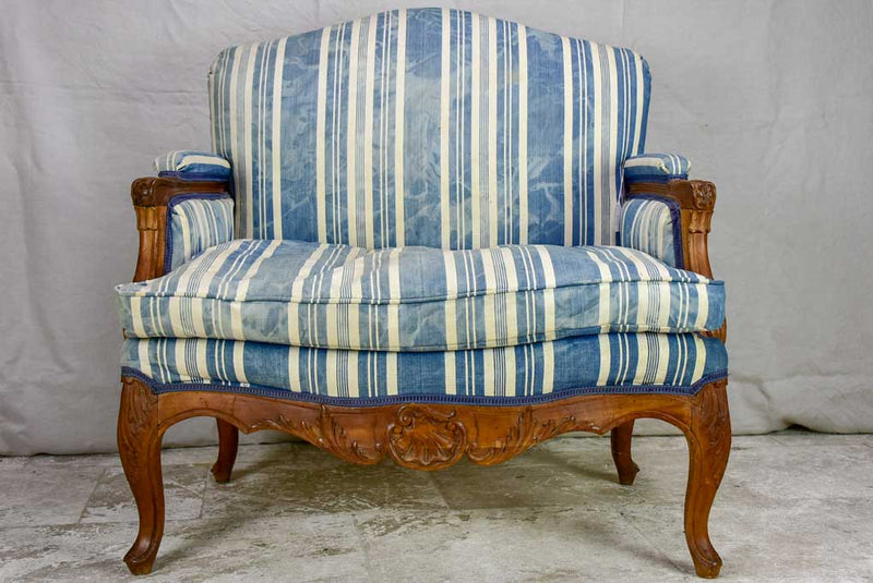 Large antique French Provincial armchair with striped blue and white upholstery walnut frame