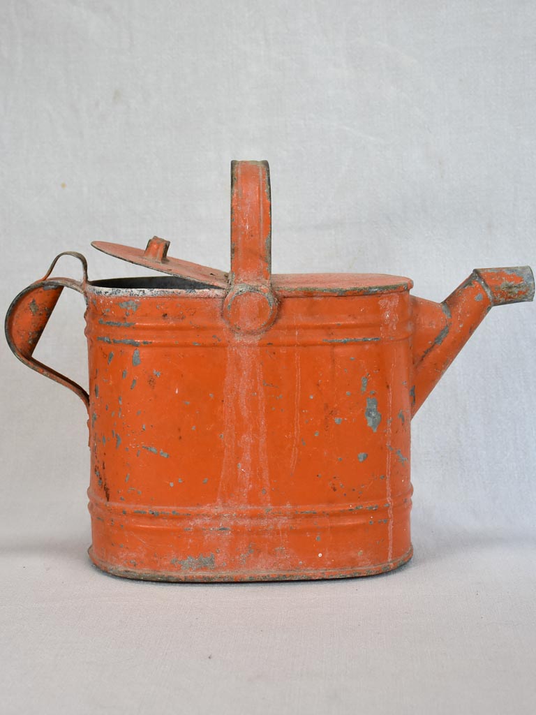 Antique French covered watering can with red patina