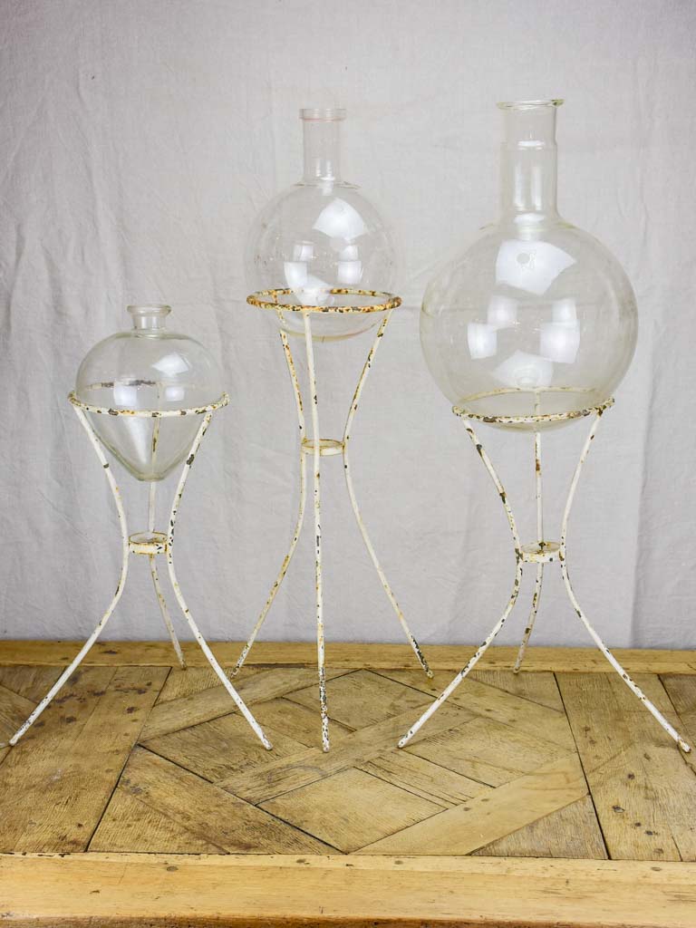 Group of three vintage flasks mounted on iron tripod stands