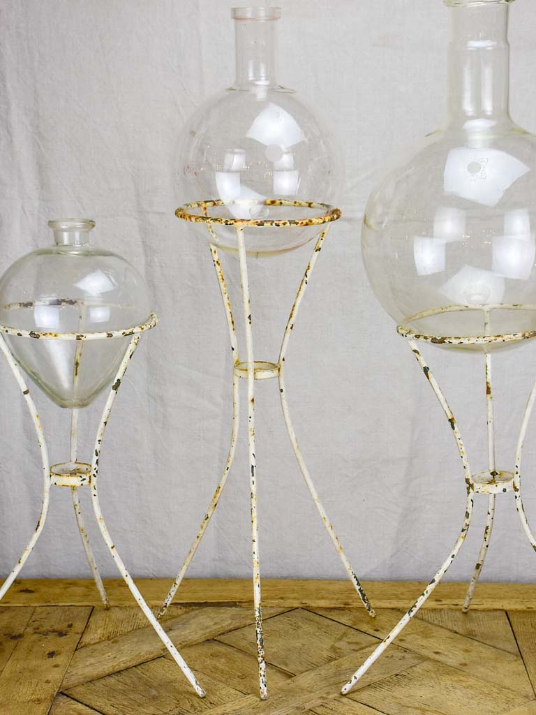 Group of three vintage flasks mounted on iron tripod stands