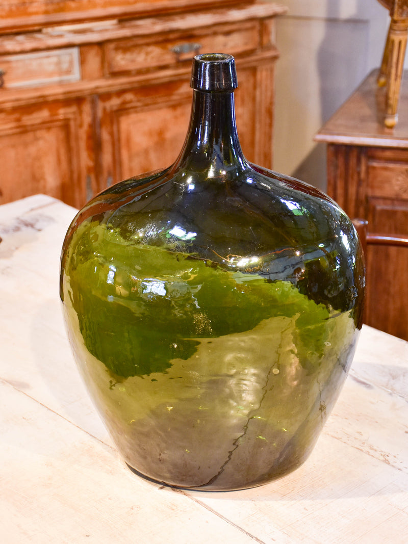 Large oval demijohn with dark green glass