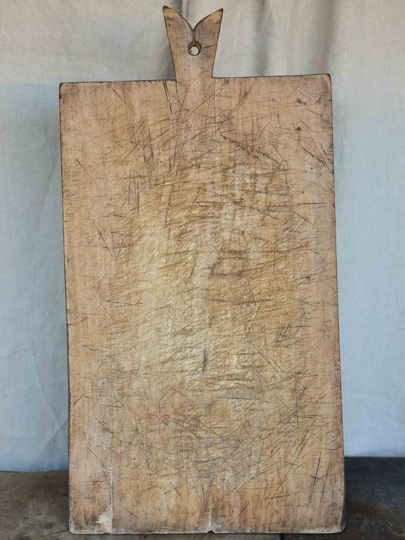 Very large antique French cutting board with fishtail handle