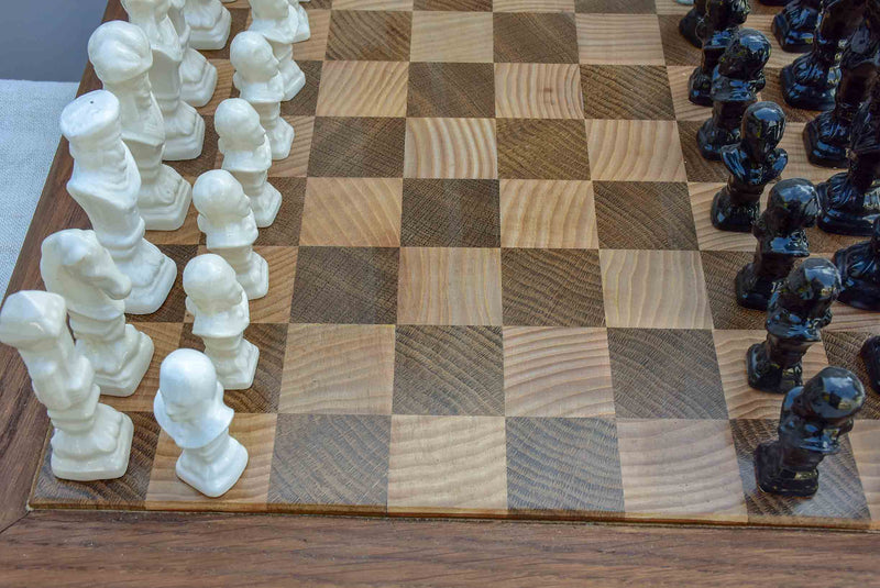 Vintage wooden chess board with porcelain pieces