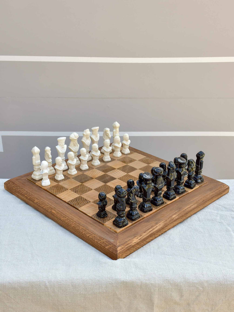 Vintage wooden chess board with porcelain pieces
