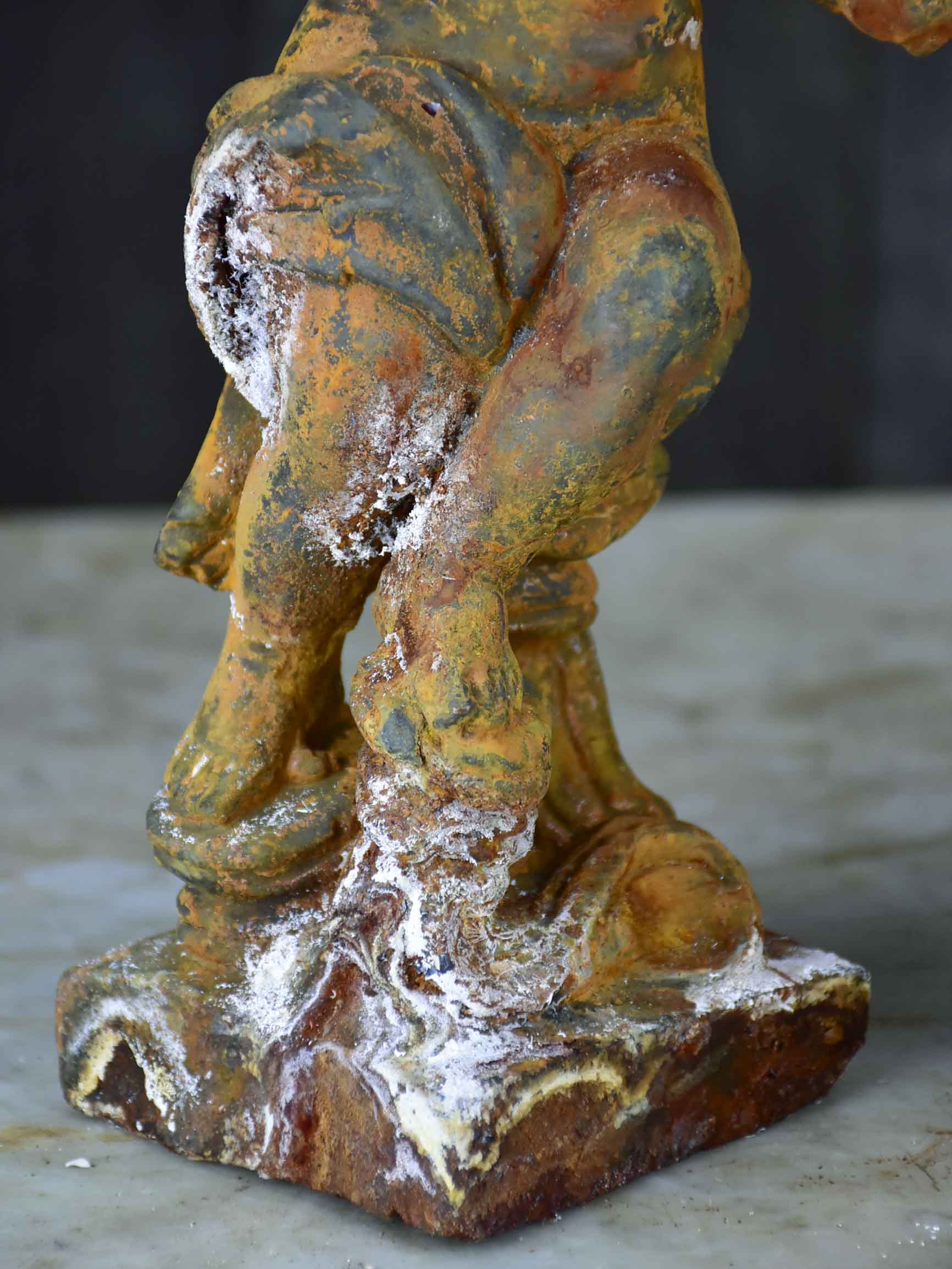Two antique cast iron cherubs playing musical instruments