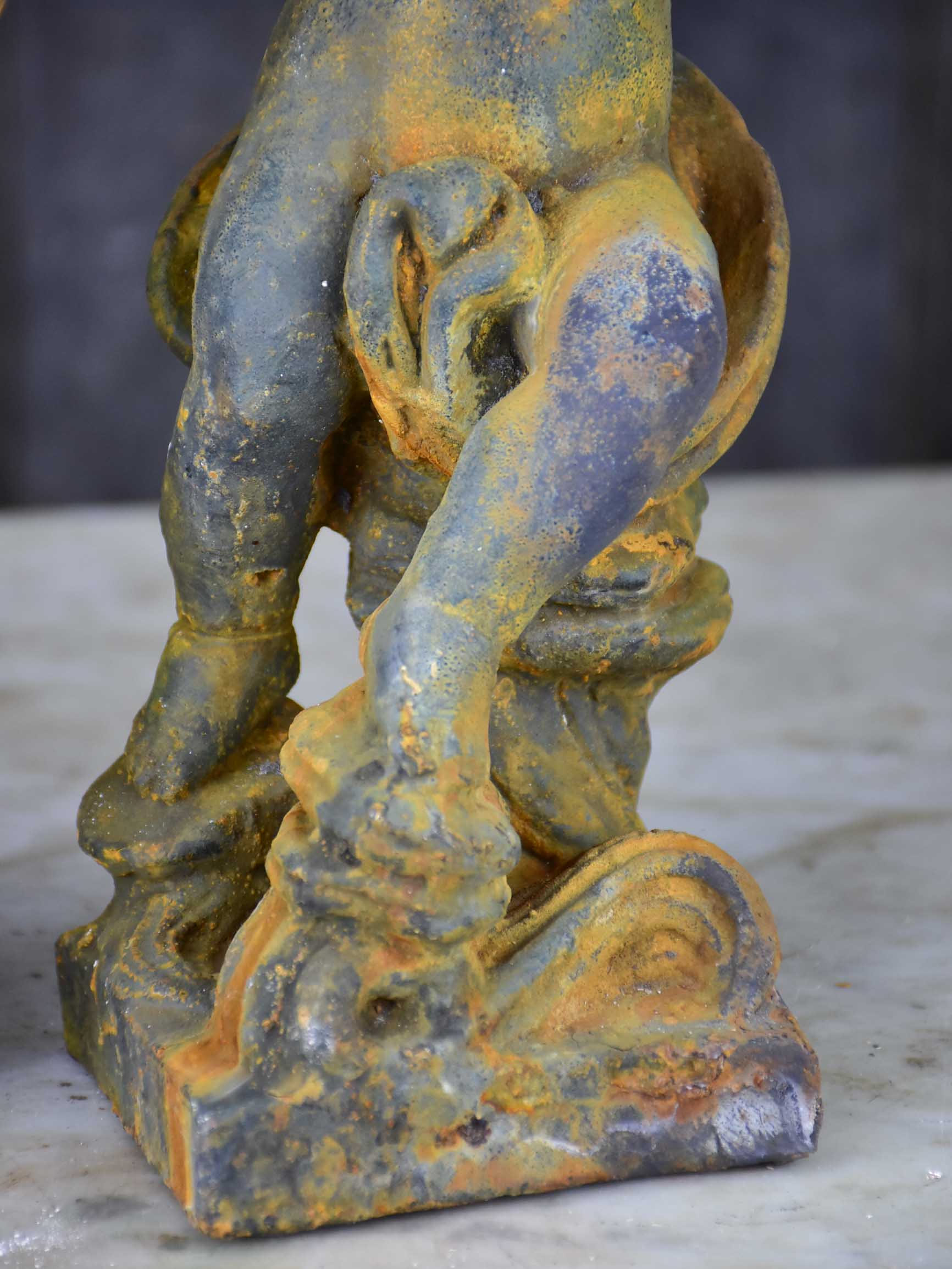 Two antique cast iron cherubs playing musical instruments