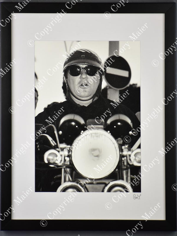 Framed, monochrome French comedian Coluche portrait