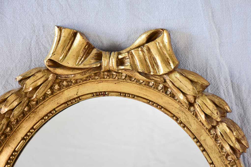 Louis XVI style oval mirror with large bow pediment 20¾ x 28¾