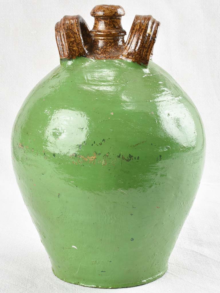 Antique water jug with green paint finish