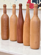 Collection of five wooden sculptures in the shape of bottles