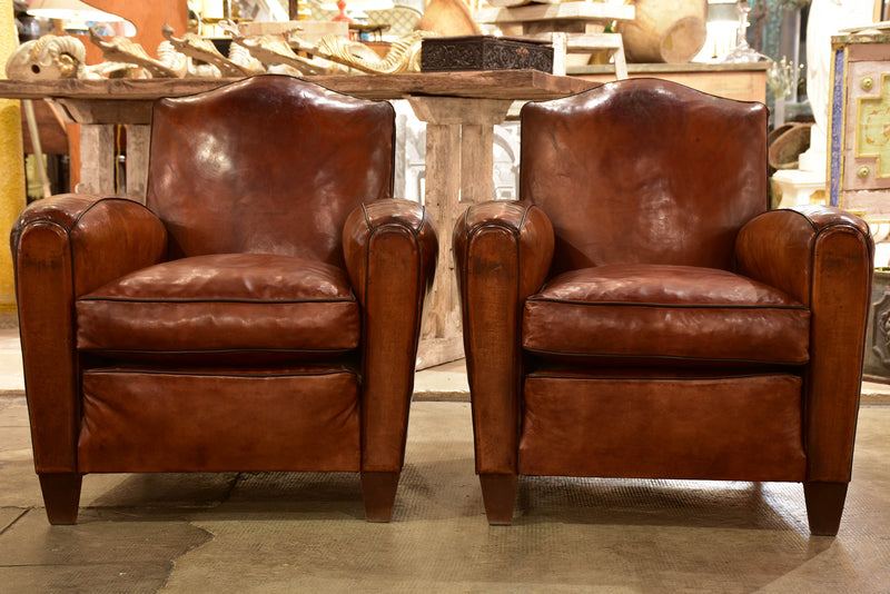 Pair of vintage French leather club chairs with chapeau gendarme