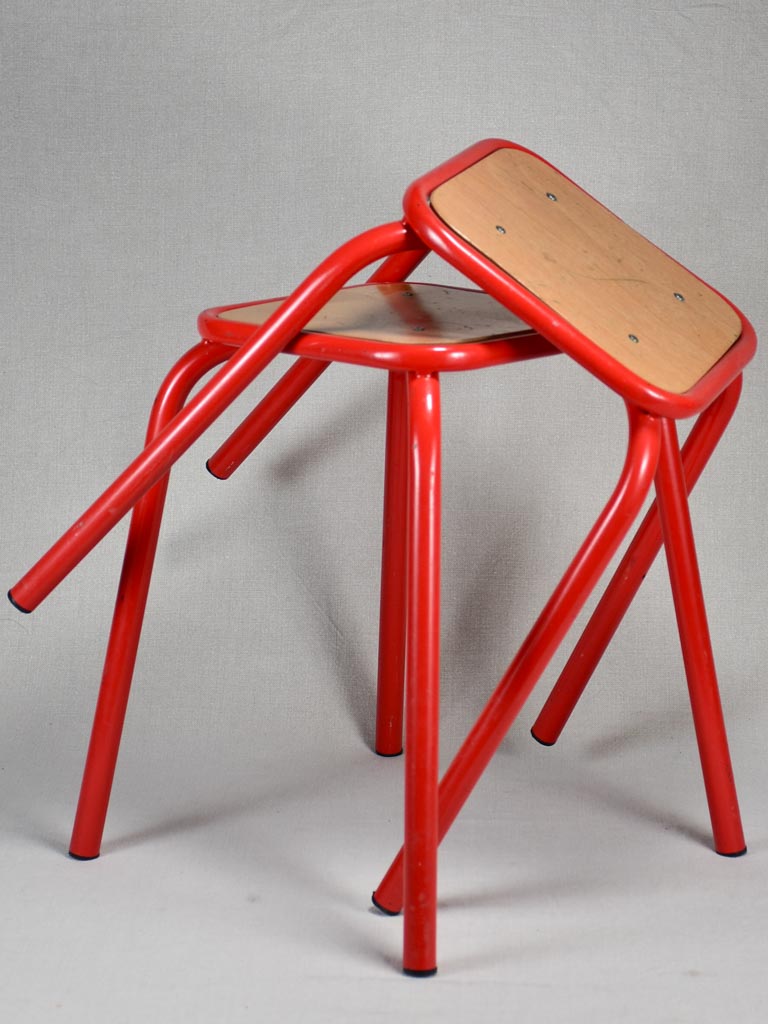 Set of ten red vintage stools from a school