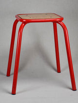 Set of ten red vintage stools from a school