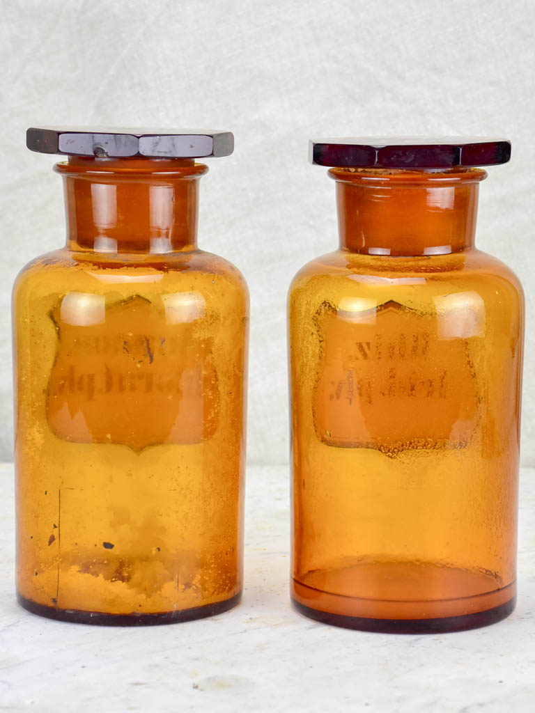 Two amber glass antique French apothecary jars with octagonal lids