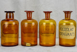 Four antique French apothecary jars with original glass lids - amber