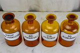 Four antique French apothecary jars with original glass lids - amber