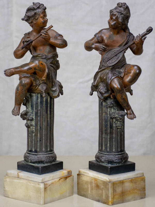 Antique French statues of angels playing music