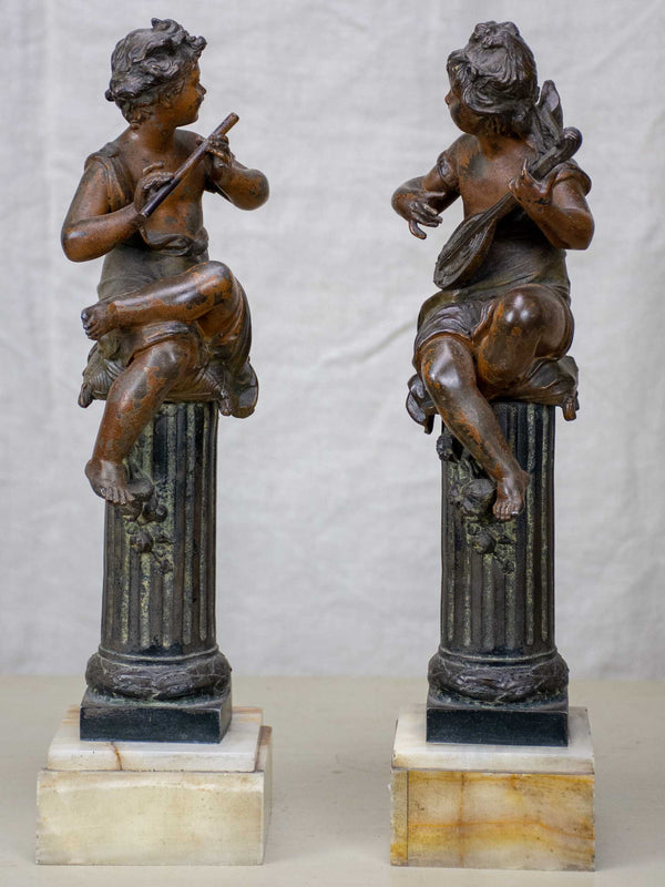 Antique French statues of angels playing music