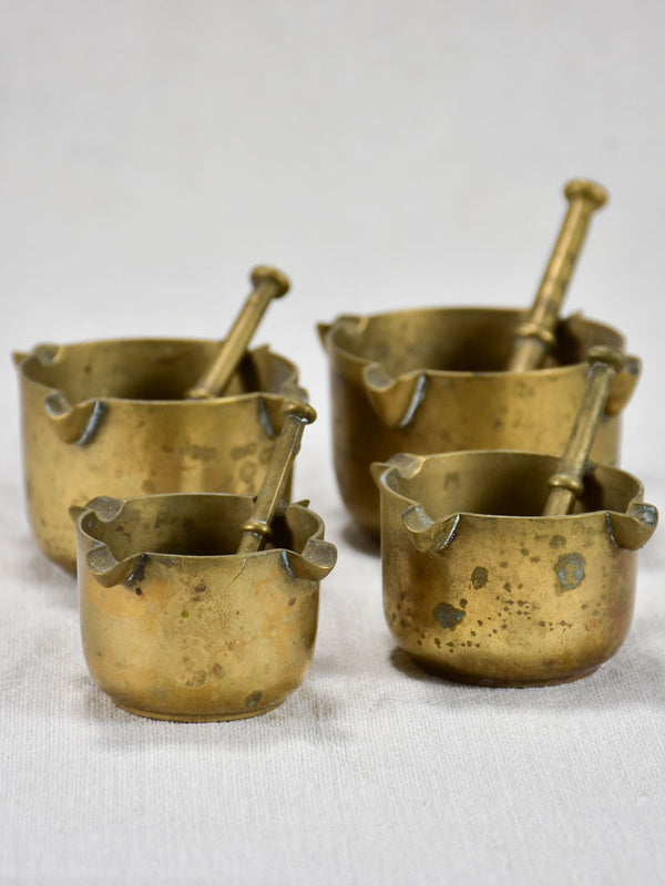 Collection of miniature bronze mortar and pestle ash trays from a bistro