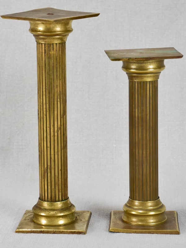 Two small brass presentation columns from a boutique