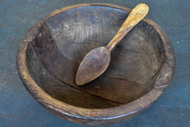 An antique French wooden bowl with repairs