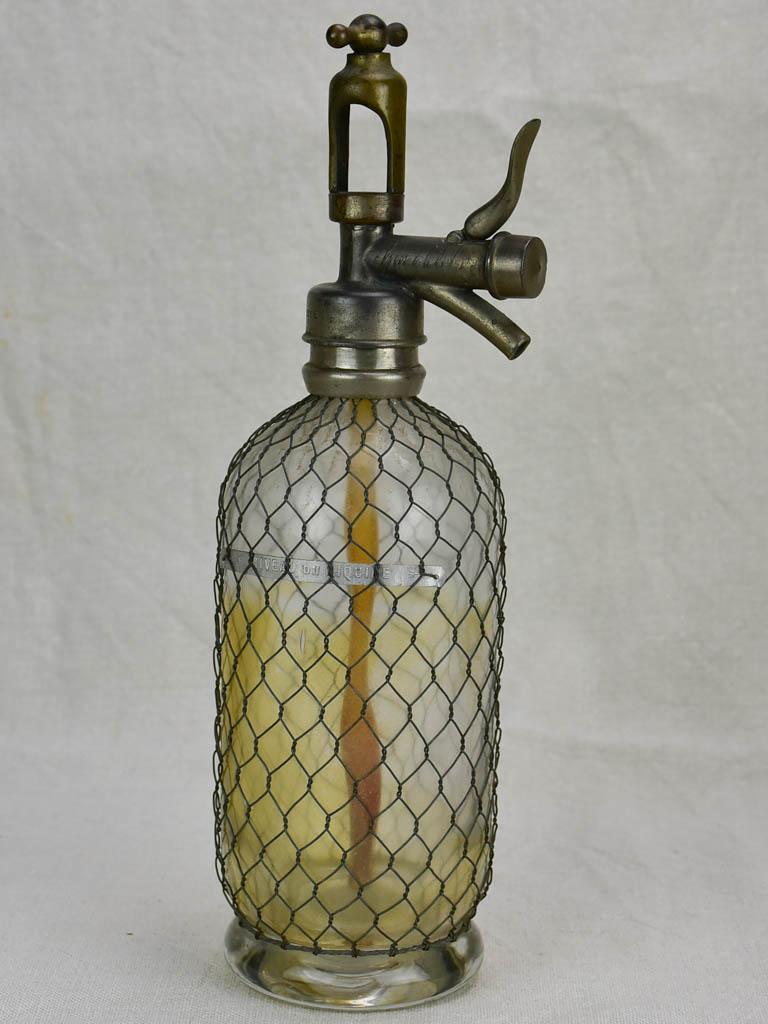 Antique French seltzer bottle in wire