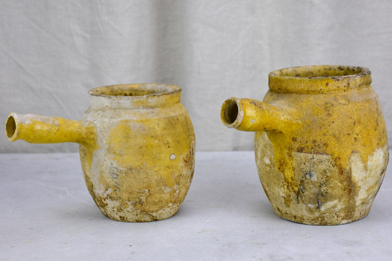 Two antique French cooking pots with one handle and yellow glaze