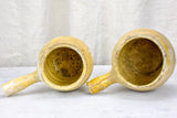 Two antique French cooking pots with one handle and yellow glaze