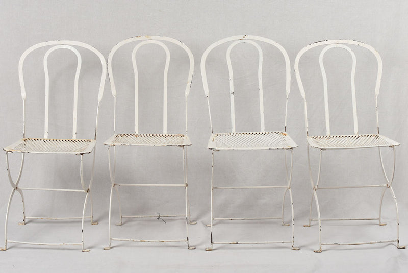 Set of four white folding garden chairs