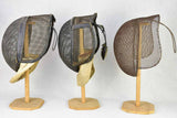 Collection of three antique French fencing masks on vintage hat stands