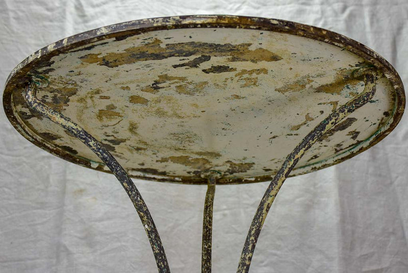 Antique French bistro table with timeworn beige patina