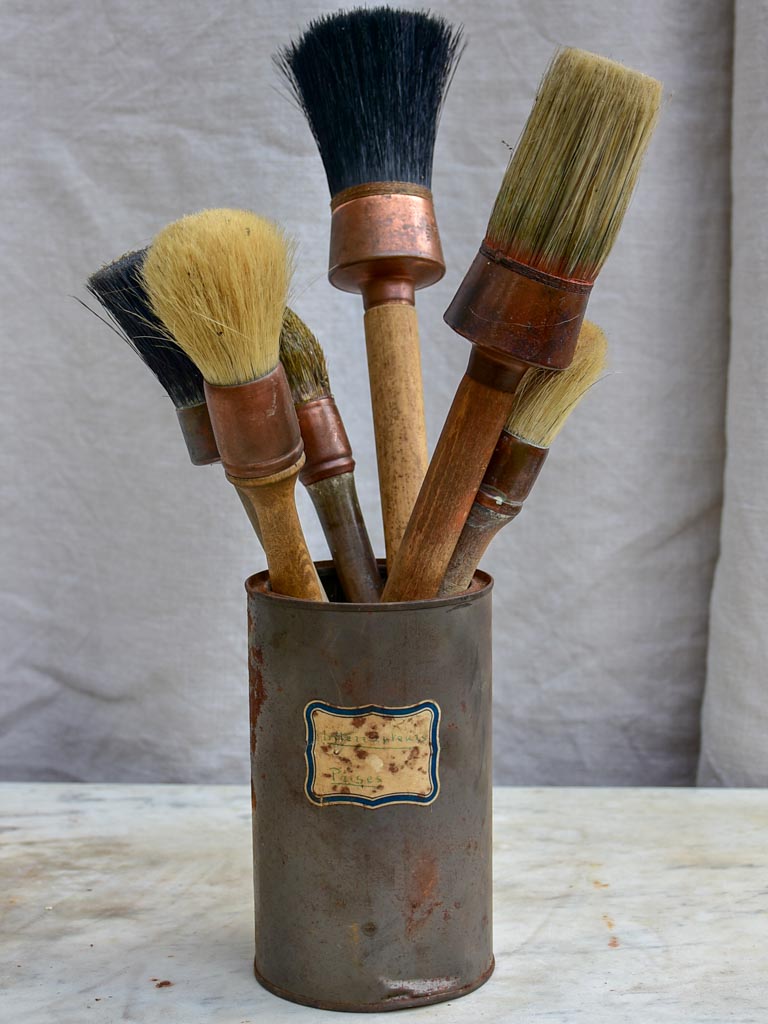 Collection of vintage paint brushes in a tin