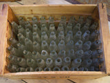 Rustic fruit box containing vintage glass bottles