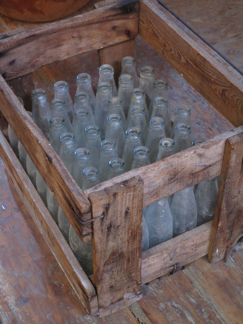 Vintage juice bottles in a rustic wooden box